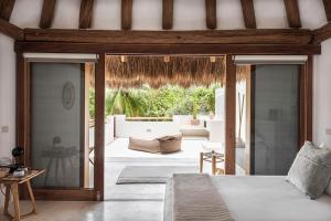 a bedroom with a bed and a patio at Tierra del Mar Hotel - Adults Only in Holbox Island