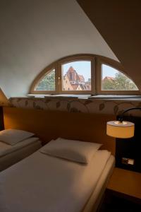 1 dormitorio con 2 camas y ventana en Hotel Bulwar, en Toruń