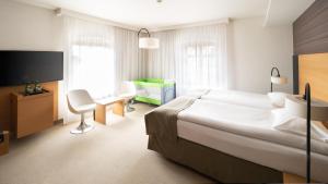 a hotel room with a bed, chair, and nightstand at Hotel Bulwar in Toruń