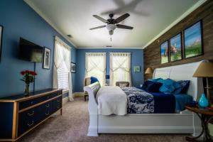 ein blaues Schlafzimmer mit einem Bett und einem Deckenventilator in der Unterkunft The Nordic Pineapple Bed and Breakfast in Saint Johns