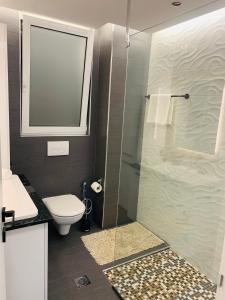 W łazience znajduje się toaleta i przeszklony prysznic. w obiekcie Apartment Marla w mieście Rodos +15 zdjęć