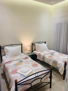 dwa łóżka siedzące obok siebie w pokoju w obiekcie Apartment Marla w mieście Rodos