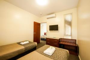 a hotel room with two beds and a television at Strath Motel in Strathalbyn