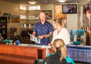 a man and a woman standing at a cash register at Strath Motel in Strathalbyn