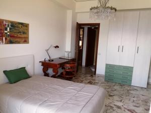 a bedroom with a bed and a desk and a chandelier at The door of Sicily in Messina