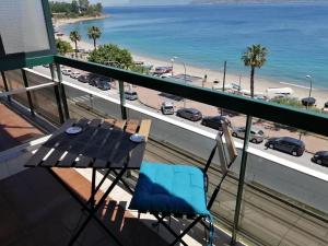 a balcony with a table and a view of a beach at The door of Sicily in Messina
