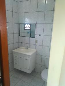 a white bathroom with a sink and a toilet at Casa com vista para o Mar in Ilhabela +7 photos