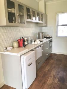 a kitchen with a sink and a white refrigerator at Meander Retreat - The Green Room in Springton