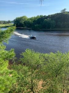 a boat is traveling down a river with trees at Colonial motel in Wisconsin Dells