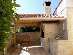 una cocina al aire libre con techo y fregadero en Villa Jukic Murter, en Murter