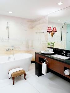 a bathroom with a tub and a large mirror at Hotel Celeste Makati in Manila