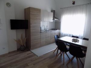 eine Küche mit einem Tisch und Stühlen sowie ein Esszimmer in der Unterkunft Villa Jukic in Murter