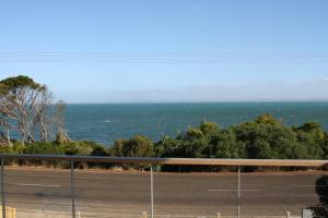a view of the ocean from a road at Camelot in Kingscote