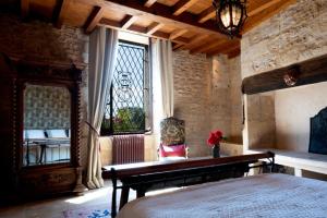 een slaapkamer met een bed en een glas-in-loodraam bij La Source, Beynac, Dordogne in Beynac-et-Cazenac