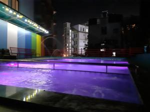 una piscina por la noche con luces moradas en Khách sạn Anh Đào en Tam Ðảo