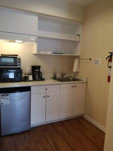 a kitchen with a sink and a microwave at Coquihalla Motel in Hope