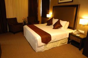 een hotelkamer met een groot bed en een telefoon bij Felda Residence Kuala Terengganu in Kuala Terengganu