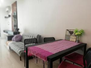 a dining room with a table and a couch at Twin Galaxy Residences in Johor Bahru