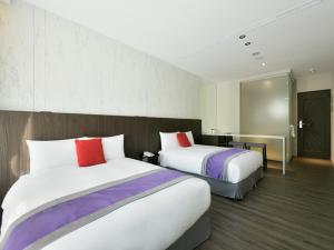 Säng eller sängar i ett rum på Hotel Hesper HSR Taichung