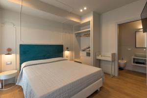 a bedroom with a bed and a bathroom with a sink at Diecidodici BoutiqueRooms in Sirolo