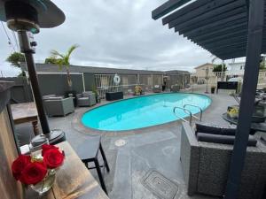 a swimming pool with a table and red roses at Shell Beach Inn in Pismo Beach