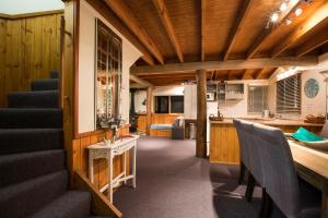 a living room with a staircase and a kitchen at Kummonin in Dinner Plain