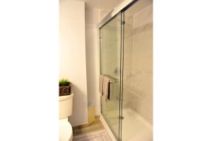 a glass shower in a bathroom with a toilet at Dream Catcher Travel House in Toronto
