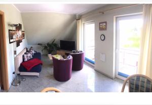 a living room with two chairs and a television at Ferienwohnung Altenkirchen 1 in Altenkirchen