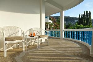 un porche con 2 sillas y una mesa en el balcón en Pen Villa Hotel, Surin Beach - SHA Extra Plus en Surin Beach