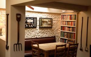 uma sala de jantar com mesa e estantes em The King's Head em Holt