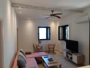 a living room with a couch and a flat screen tv at LIOTRIVI Olive Press in Volimes