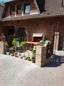 a brick house with a patio with potted plants at Garten Eden in Lubmin