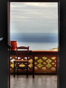 a table and a chair in front of a window at Artemis House in Karpathos