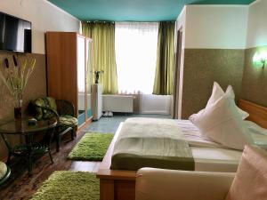 a hotel room with a large bed and a table at Pensiunea Carina in Bran