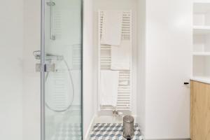 een witte badkamer met een douche en een wastafel bij Demeur in Brussel