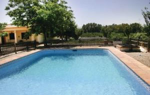 a large blue swimming pool in front of a fence at Casa Rural Los Naranjos in Almodóvar del Río