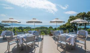 - un coin repas avec des tables, des chaises et des parasols dans l'établissement Delfinia Hotel & Bungalows, à Mithimna