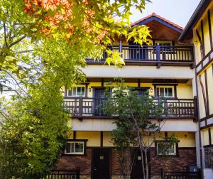um edifício de apartamentos com varanda e árvores em 清境英格曼花園民宿 em Ren'ai