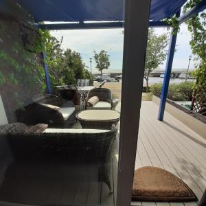 a porch with chairs and a table with a view of the ocean at Pervalka 13-5 in Pervalka