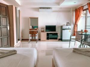 a living room with two beds and a television at Rinn Boutique House in Chiang Mai +38 photos