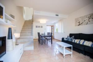 a living room with a black couch and a table at Casa Ocean by MarCalma in Montroig