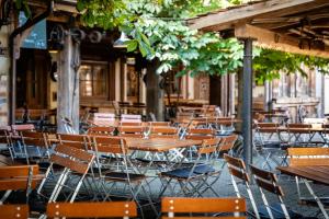 an outdoor restaurant with wooden tables and chairs at Hotel Gasthof Rössle in Weingarten