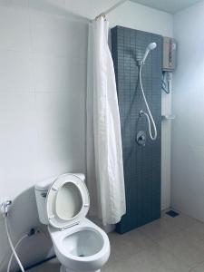 a bathroom with a toilet and a shower with a shower curtain at J Hotel in Ao Nang Beach