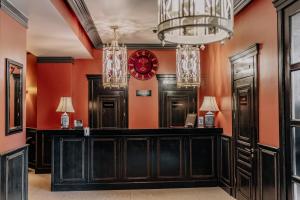 un bar con paredes de color naranja y reloj rojo en Plaza Hotel, en Kokshetau