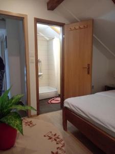 1 dormitorio con 1 cama y puerta al baño en Guesthouse Marton, en Jezerce