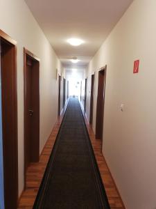 a long hallway with doors and a long carpet at Hotel Arli in Senica