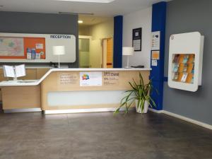 a waiting room at a hospital with a reception counter at Ibis Budget Girona Costa Brava in Girona