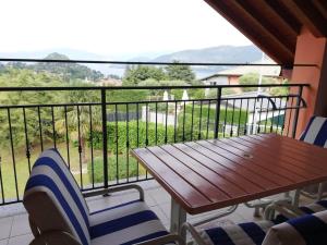 a balcony with a wooden table and chairs and a view at Villa Anna in Porto Valtravaglia
