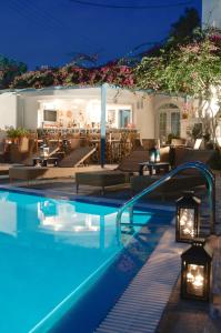 a swimming pool with lights in a hotel at night at Hotel Matina in Kamari