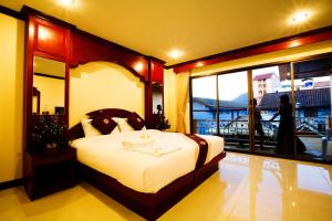 sypialnia z dużym łóżkiem i balkonem w obiekcie Baan Sudarat Hotel w Patong Beach